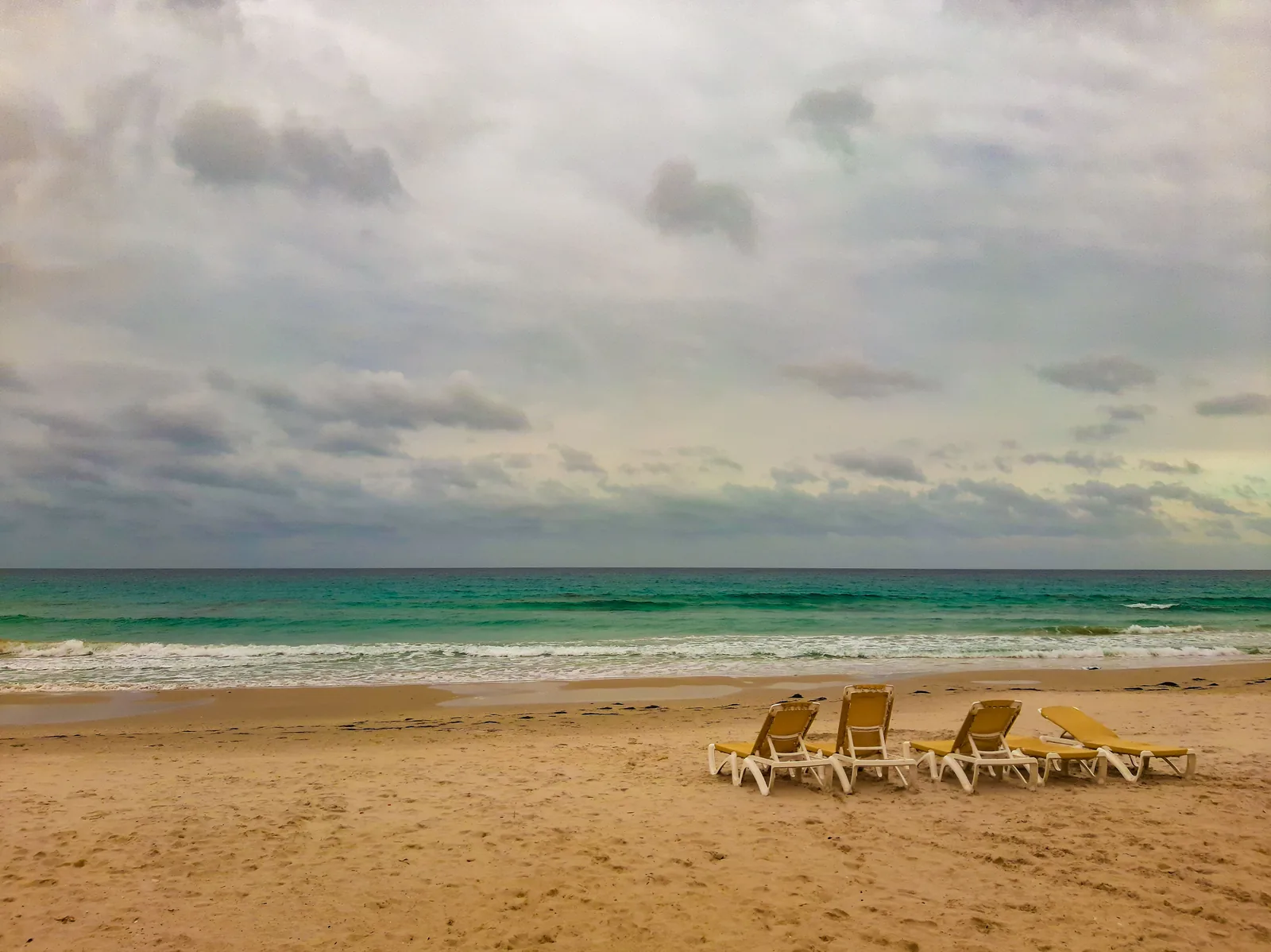 Empty deck chairs, overcast beach, off season.